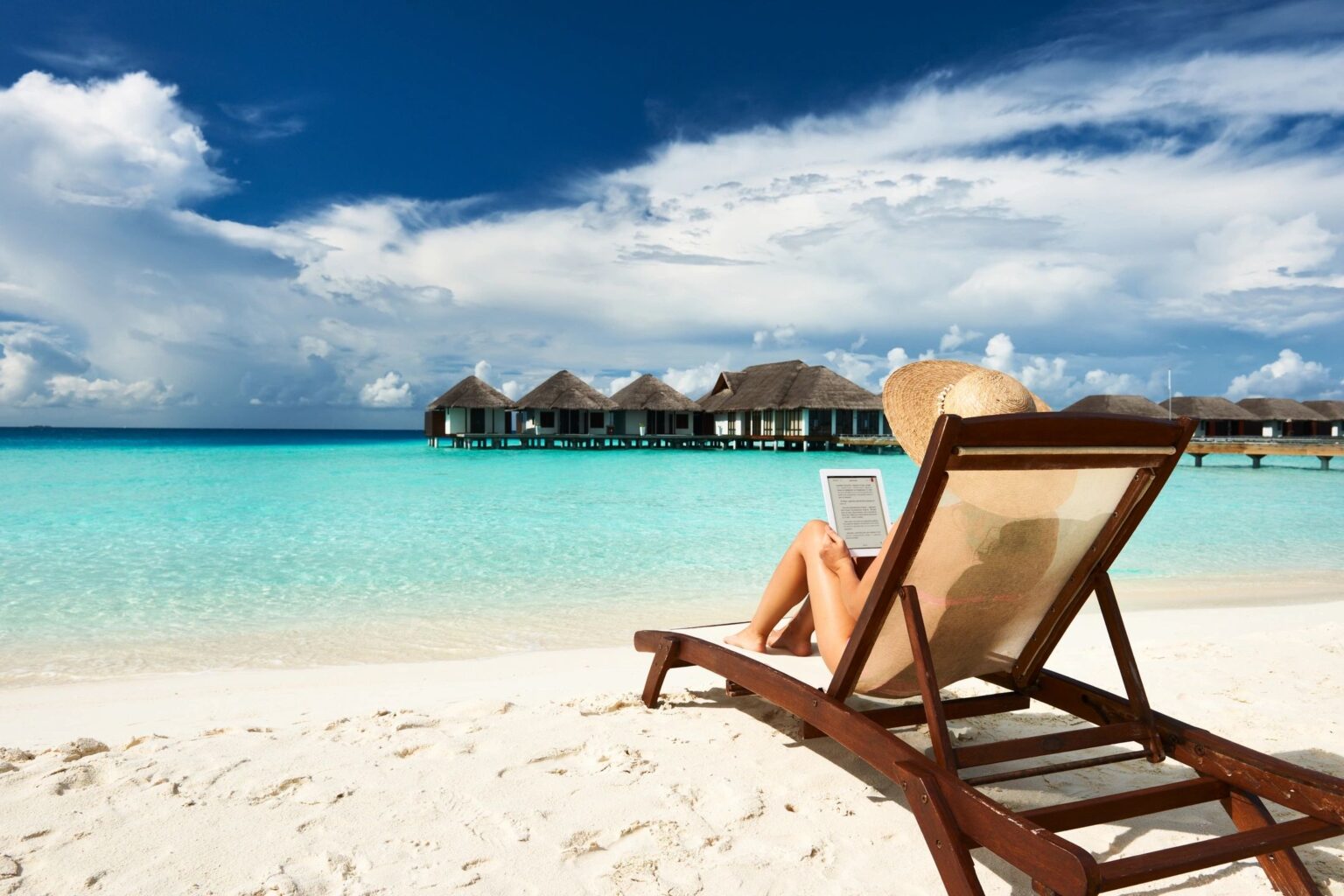 Woman sitting on a beach chair enjoying a vacation.